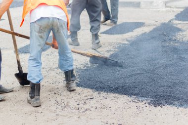 Road Street onarım çalışmaları sırasında kaldırım makinesindeki işçiler