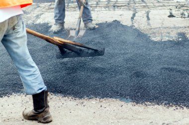 Road Street onarım çalışmaları sırasında kaldırım makinesindeki işçiler