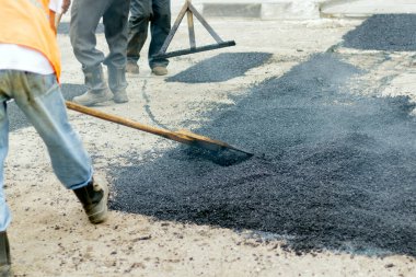 Road Street onarım çalışmaları sırasında kaldırım makinesindeki işçiler