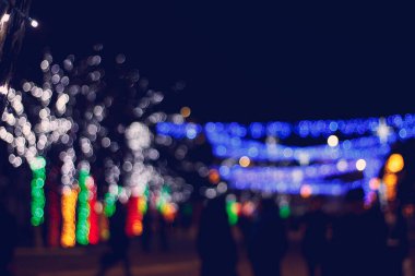 Geceleri şehrin bulanık arkaplanı Noel ışıklarıyla bulanıklaşıyor..