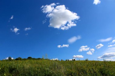 Sıcak güneşli bir yaz gününde manzara, bir yazı veya metin için alanı olan alan ve bulutlar, arkaplan