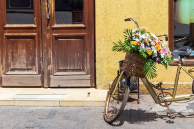 Bisikletin gidonunda çiçek tarhı olan bir sepet, Avrupa sokaklarının dekoru..