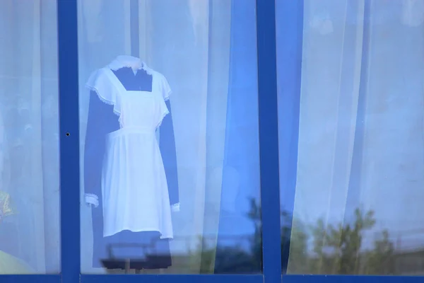 School uniform behind the glass of a large window on a mannequin