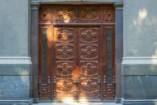 Rzeźbione Drewniane Podwójne Zamknięte Drzwi Oświetlone Plamami Słonecznymi Ulicy Miasta — Zdjęcie stockowe