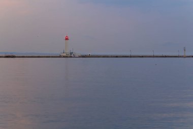 Deniz feneri gün batımından sonra, arka planda
