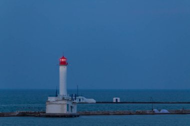 Deniz feneri gün batımından sonra, arka planda