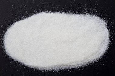 Şeker siyah bir arkaplana saçılmış, başlık altında bir yazı ve yazı için boşluk var. Manşet için kopyalama alanı. Şekil ve sağlık için kullanım özellikleri ve etkileri kavramı