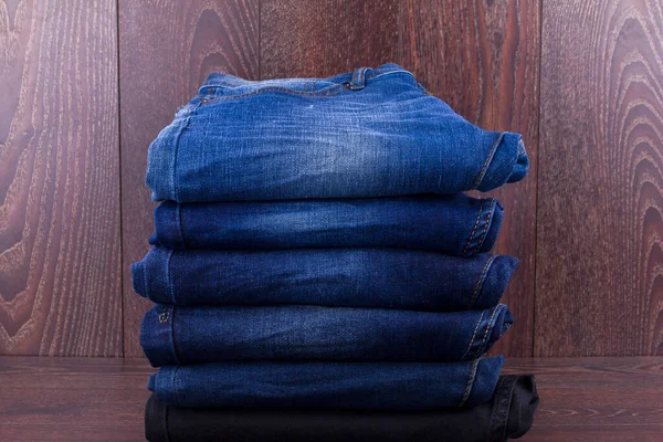 木製の背景に折りジーンズ — ストック写真