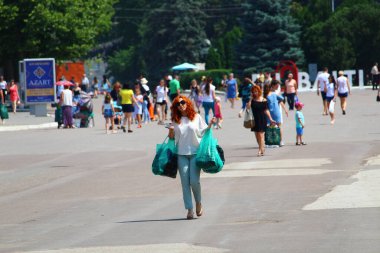 25 Haziran 2019, Balti, Moldova, elinde alışveriş paketleri olan kadın çarşıdan şehir meydanına gider.