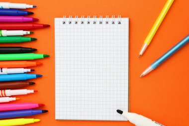 Boş işaretlenmiş defterleri ve turuncu arka planda çok renkli işaretleri aç. Kopyalama alanı ile modelleme.