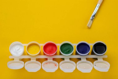 Sarı arka planda çok renkli fırçayla boyanmış konteynırlar. Başlık veya metin için alanı kopyala.