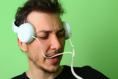 Açık yeşil arka planda etkileyici bir genç adam ya da adam. Mutluluk ve sevinç duygusu