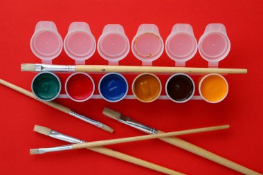 Metin veya çizim için düz sanat fırçaları ve çok renkli boyalarla dolu kavanozlar. Analog yaratıcılık kavramı