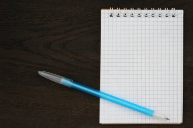 Boş defter ve kalemi aç. Kopyalama alanı olan bir model. Ahşap arkaplan