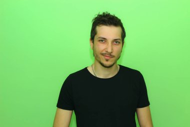 Açık yeşil arka planda etkileyici bir genç adam ya da adam. Küçümseme duygusu