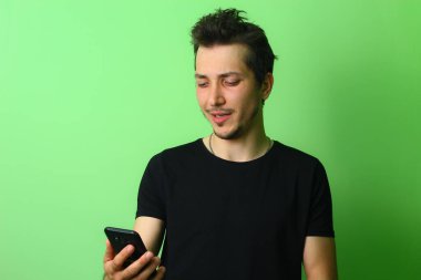 Açık yeşil arka planda etkileyici bir genç adam ya da adam. Üzücü duygular.