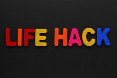 Çok renkli manyetik harflerle yazılmış bir metin. ÖLÜM HACK. Siyah arkaplan