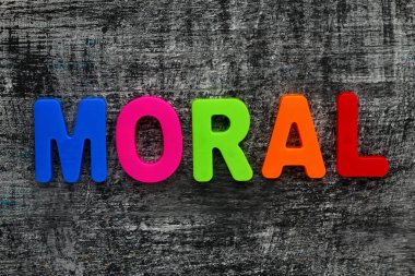 Çok renkli manyetik harflerle yazılmış bir metin. Ahlak. Çizilmiş ahşap grunge arkaplanı.