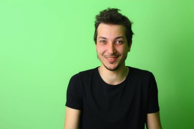 Açık yeşil arka planda etkileyici bir genç adam ya da adam. Mutluluk ve sevinç duygusu