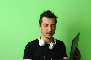 Açık yeşil arka planda etkileyici bir genç adam ya da adam. Hileli duygu