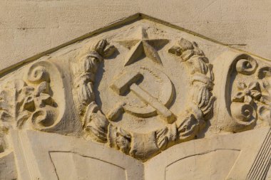 Tipik SSCB sembolleri bir binanın ön cephesindeki orak ve çekiçtir. Arkaplan