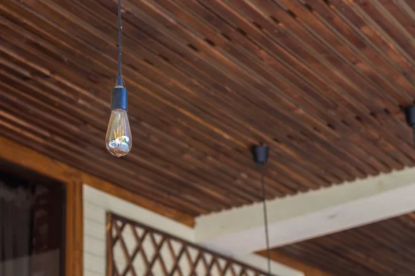 A decorative light bulb in an empty summer cafe due to a pandemic. Background