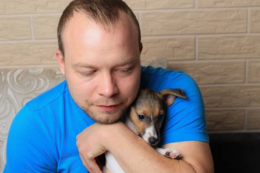 Sevgili evcil hayvanıyla birlikte beyaz bir adamın hayat tarzı portresi. Köpeklere sevgi ve ilgi