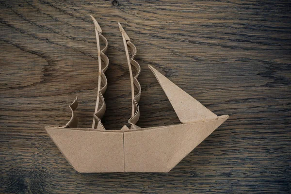 Mochila de barco a vela de papel. Foco seletivo. Fundo de madeira escuro . — Fotografia de Stock