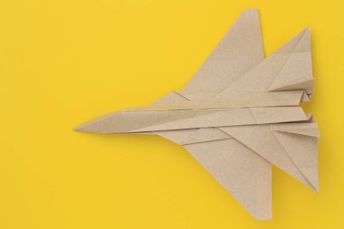 Origami kağıt uçak modeli. Seçici odaklanma. Parlak sarı arkaplan