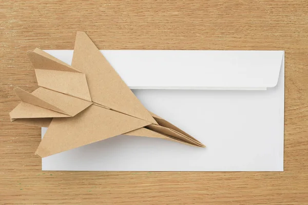 Origami paper airplane mockup. Selective focus. Against the background of a white mail envelope.