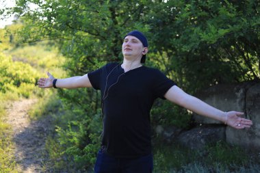 Genç beyaz bir adam ya da sıradan giyinmiş bir adam şehir dışında yaşarken doğanın güzelliğinin tadını çıkarıyor..