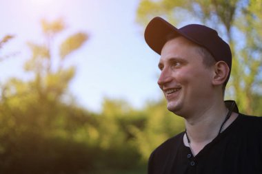 Beyaz genç adam ya da yetişkin adam parkta yürür. Ayarlanmış arkaplan.