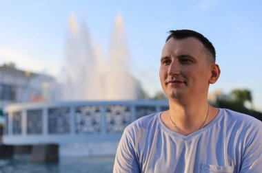 Şehir ortamında gülümseyen mutlu bir genç turist. Ayarlanmış arkaplan.