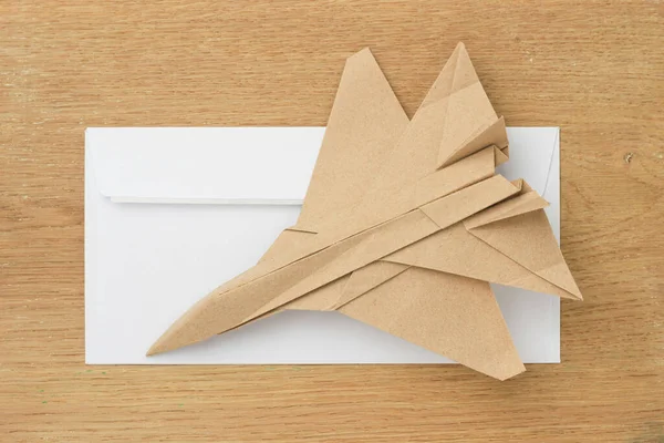 Origami paper airplane mockup. Selective focus. Against the background of a white mail envelope.