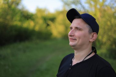 Beyaz genç adam ya da yetişkin adam parkta yürür. Ayarlanmış arkaplan.