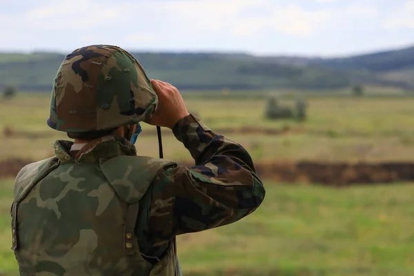 士兵用双筒望远镜看 选择性聚焦和模糊的绿色背景 — 图库照片