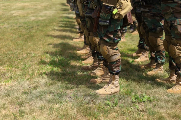 穿着军靴和衣服的真正的士兵站在草地上排成队形 带有版权空间的背景 — 图库照片