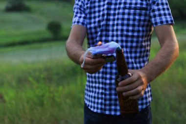 Kafkasyalı beyaz bir gencin elinin bulanık arka planında molotof kokteyli ya da sıradan giyinen yetişkin bir adamın. Tıbbi maske fitil olarak kullanılır..