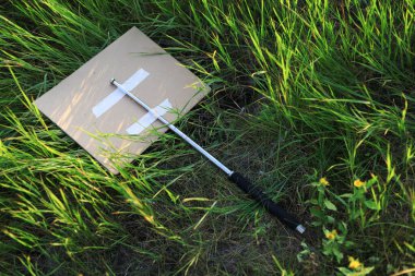 Metal periskop sopasıyla protesto eylemcileri çalılara ya da uzun otlara atıldı. Arkaplan