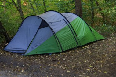 Turistler ormanda küçük bir yamaçta çadır kurarlar. Seçici odak