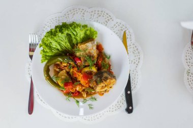 Sebzelerle pişirilmiş deniz balığı. Covid-19 tecridi sırasında evde sağlıklı beslenme yemekleri pişirmek. Bulanık arkaplan ile seçmeli odak.