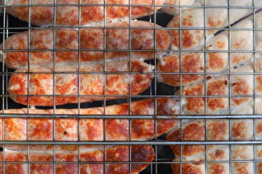 Ateşin üzerinde ev yapımı sosis pişirmek. Bulanık arkaplan ile seçmeli odak