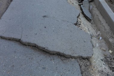 Yıkılmış ve kırılmış asfaltı olan çok kötü bir kentsel çevre. Arkaplan