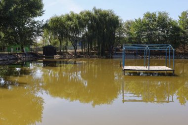 Yüzmek ve balık tutmak için yeşil tatlı suya sahip soyut göl arka planı. Seçici odak