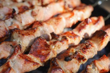 Izgarada domuz eti kızartma işlemi. Barbekülü şişler. Seçici odaklanma. Bulanık arkaplan