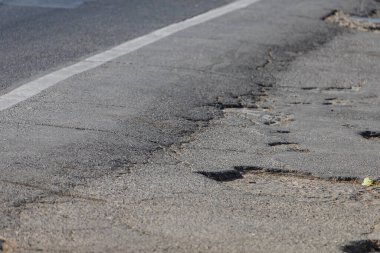 Çok engebeli bir yol. Yıpranmış bir asfalt yatak. Editör haberleri için illüstrasyon geçmişi. Acil bir elden geçirme ihtiyacı.