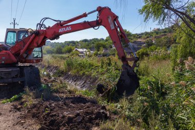 14 Eylül 2020 Balti veya Beltsy Moldova, yağmur suyu drenaj kanalının derinleştirilmesi ve temizlenmesi üzerinde çalışır. Resimli editoryal evrensel arkaplan