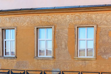 Tarihi duvar resimleri ve simetrik pencerelerle donatılmış mimari bir cephe. 16 Mart 2025, Hruba Skala Şatosu, Çek Cumhuriyeti.