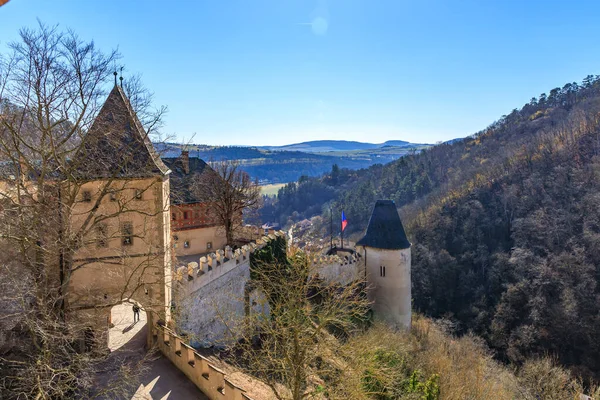 Yuvarlanan tepeler ve ormanların ortasındaki tarihi şatonun manzarası.