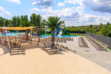 Havuzu ve bir sürü şezlongu olan bir plaj. Sandalyeler yayılmış ve bazıları havuza bakıyor. 8 Haziran 2024 Balti Moldova